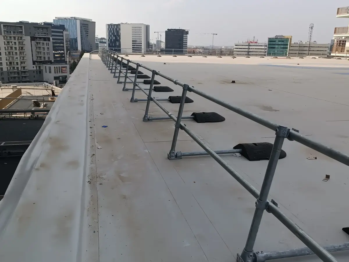 Balustradă de protecție pe acoperiș fără găurire, bloc din București – țevi și profile pe plăci de beton