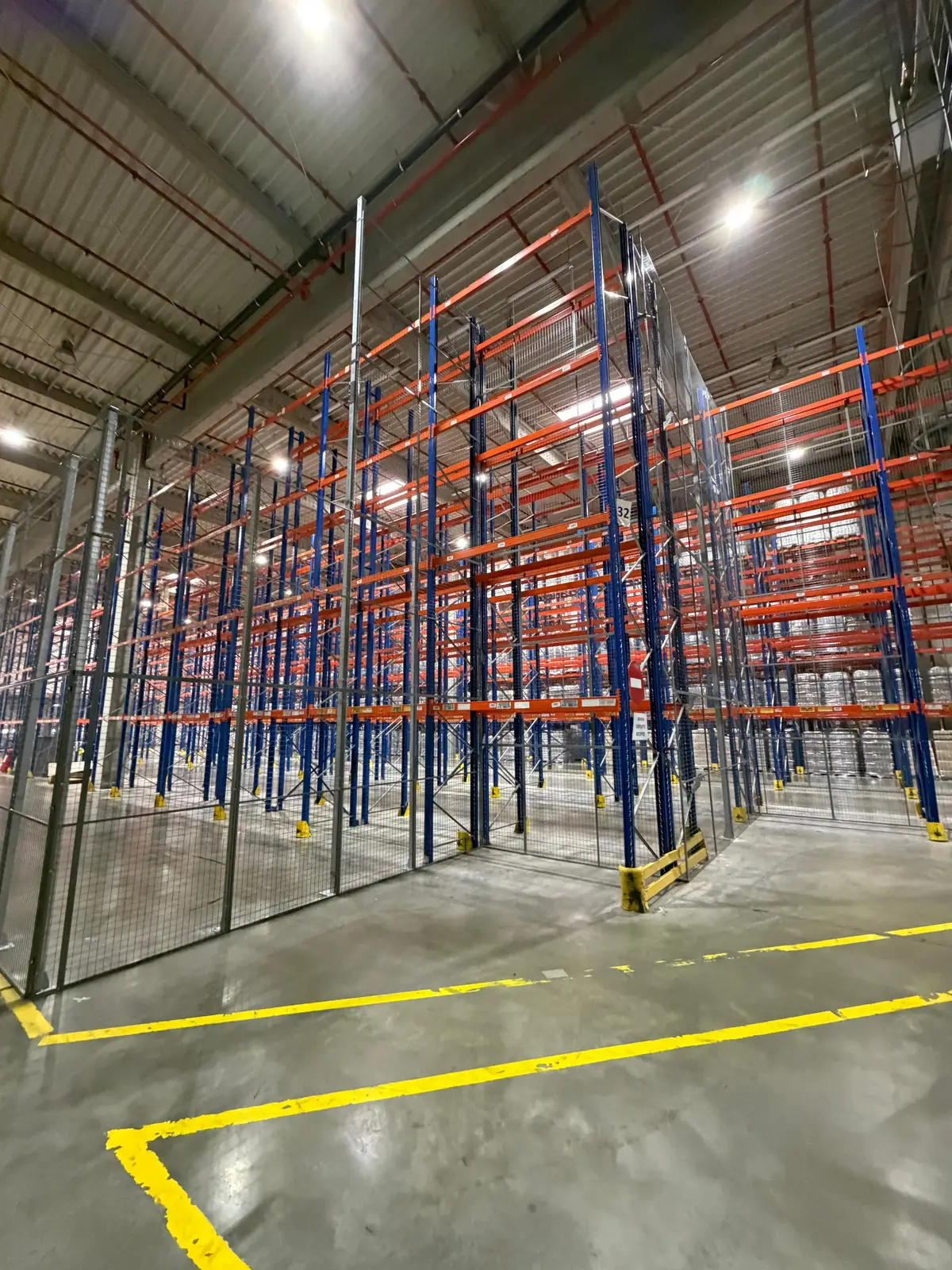 Partiționare interioară din plasă, depozit logistic Ploiești, Jungheinrich – cadre albastre, bare portocalii