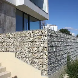 Gard din gabioane cu piatră – împrejmuire în fața unei clădiri moderne