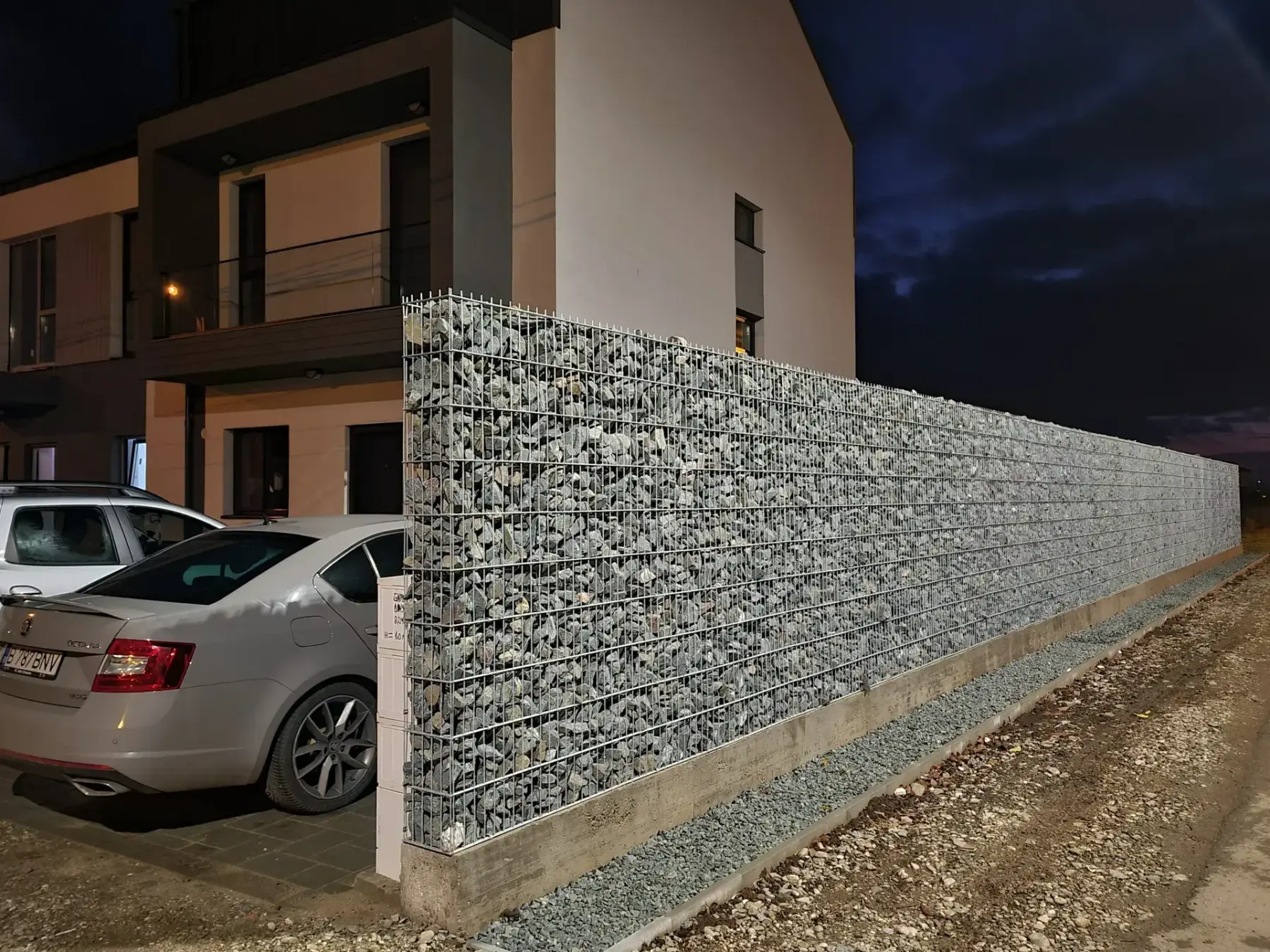 Gard din gabioane cu piatră – fundație de beton, context urban