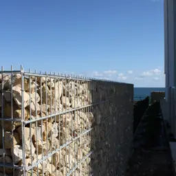 Gard din gabioane cu piatră – peisaj natural, cer albastru