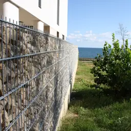 Gard din gabioane cu piatră – lângă zonă verde, vedere spre apă
