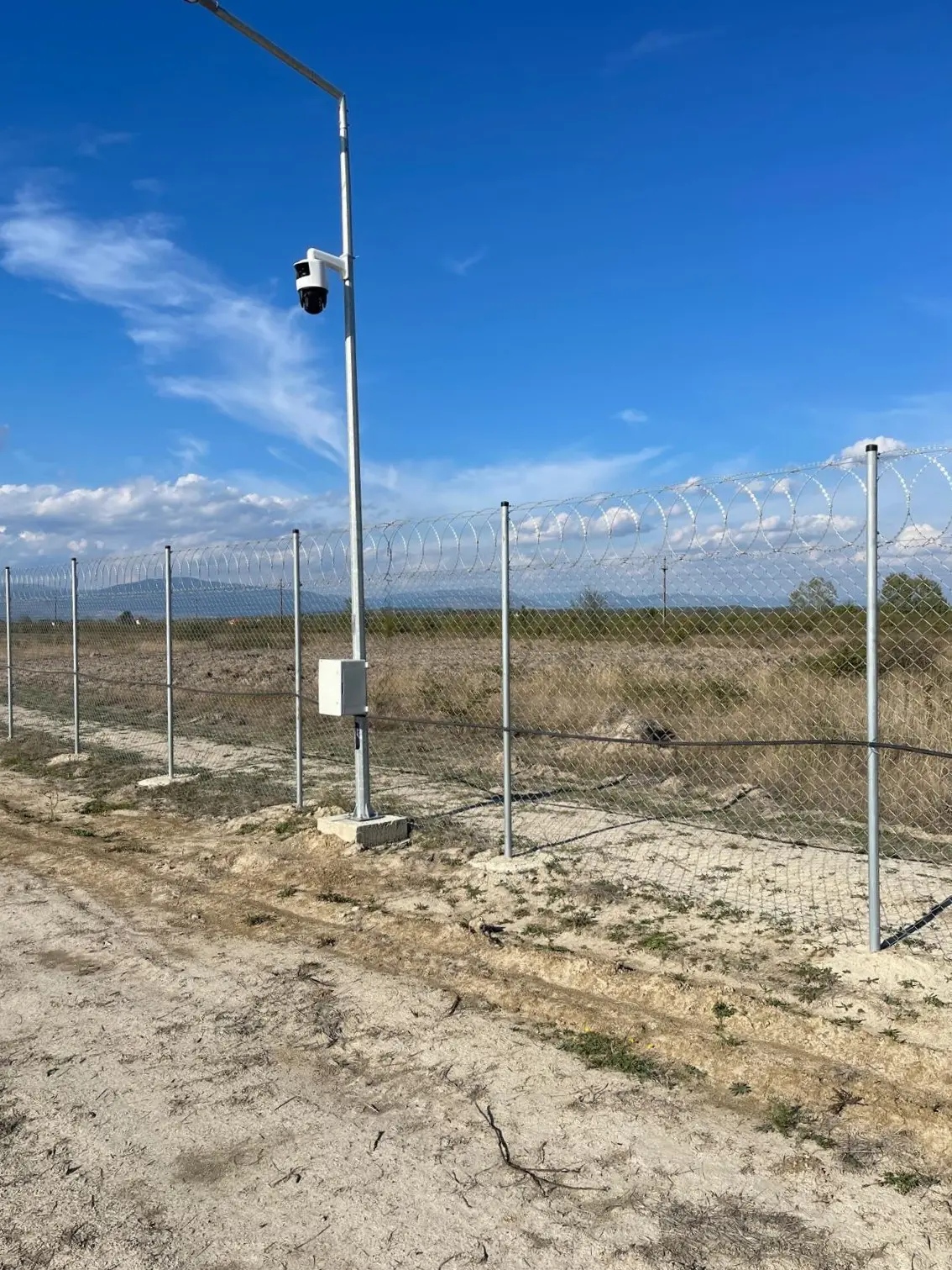 Gard de securitate cu plasă împletită zincată Flexyfort, parc fotovoltaic LPV – fundație de beton și cameră de monitorizare
