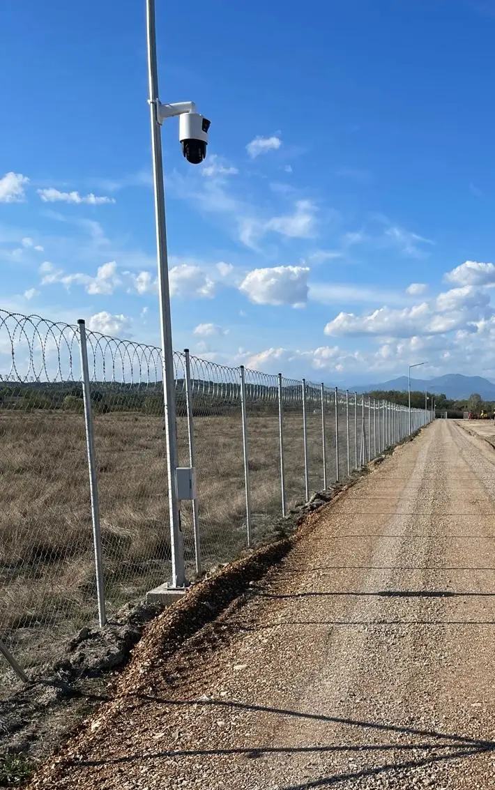 Gard de securitate cu plasă împletită zincată Flexyfort, parc fotovoltaic LPV – stâlp cu cameră de supraveghere, cer senin