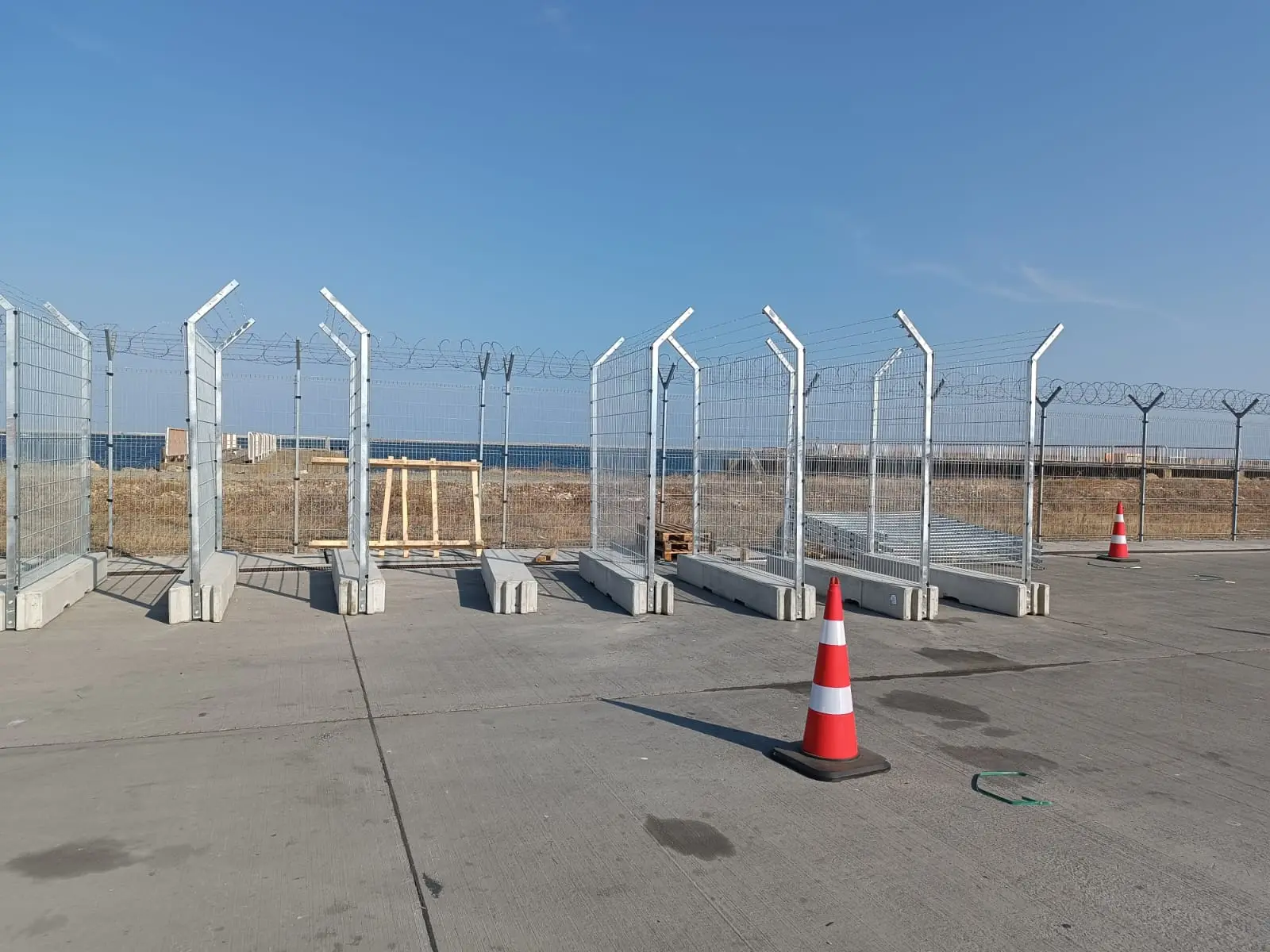 Gard mobil de înaltă securitate – sârmă ghimpată și conuri în prim-plan