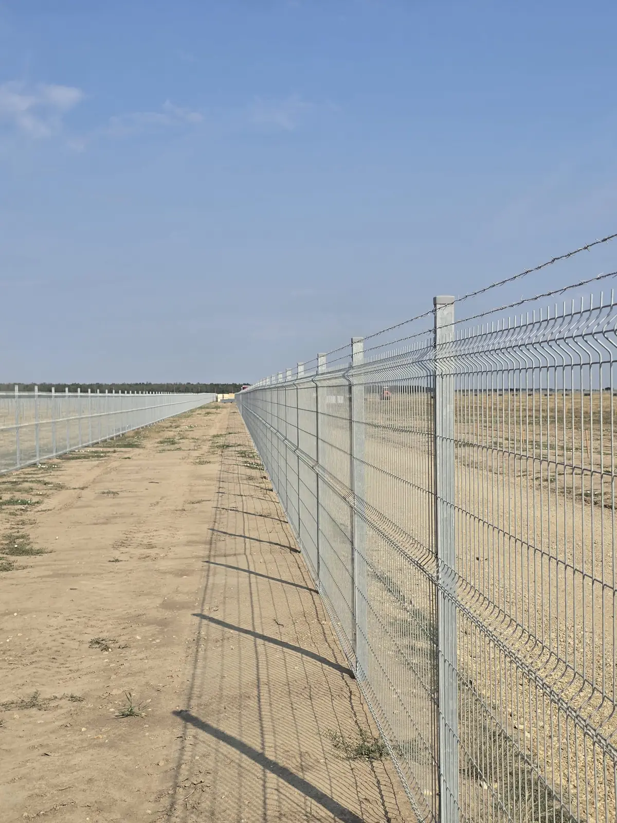 Împrejmuire parc fotovoltaic Răscăeți cu panouri bordurate zincate la cald – gard lung pe teren arid