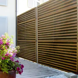 Gard fonoabsorbant din lemn Noistop Wood – plante și flori în fundal