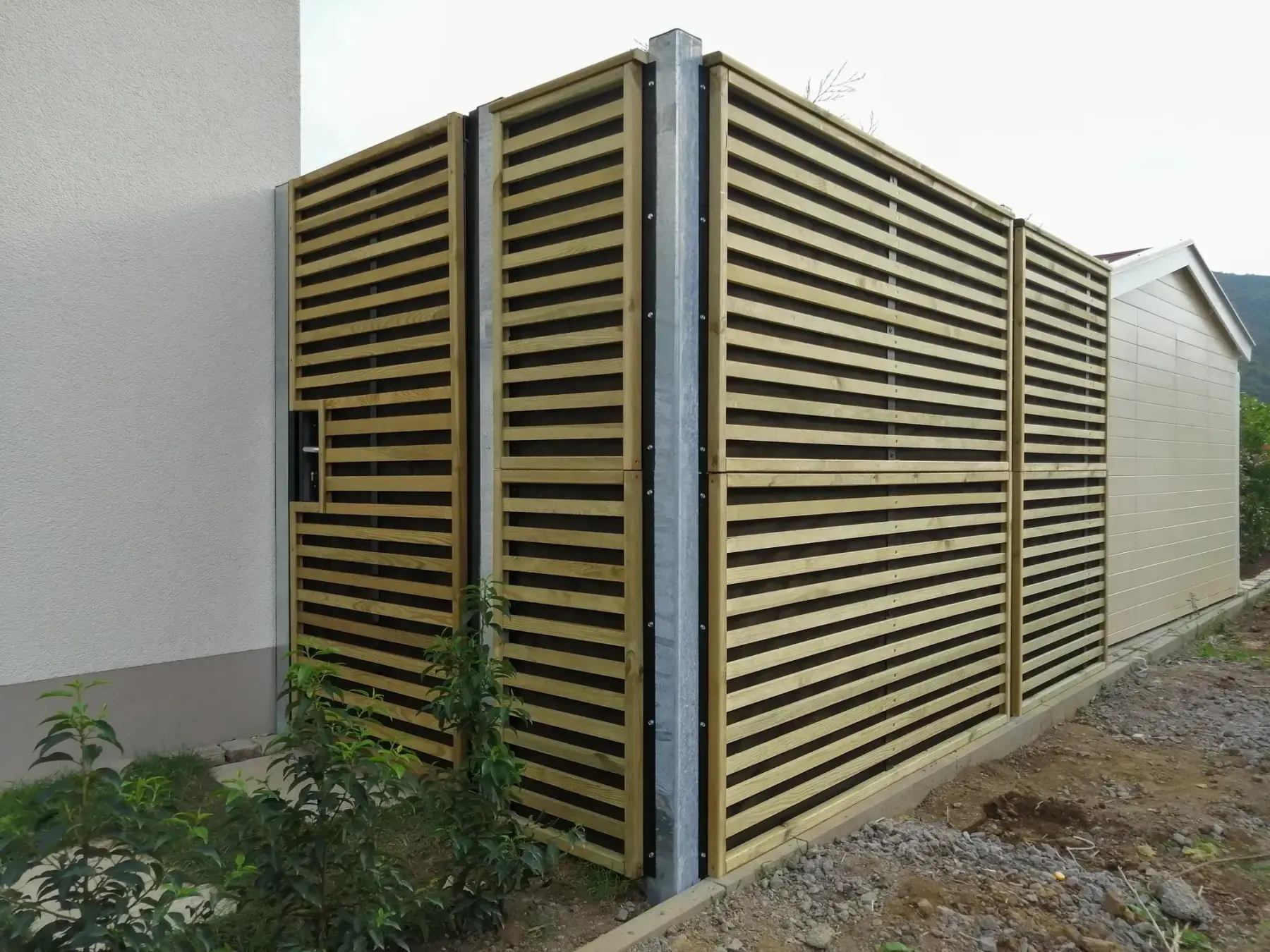 Gard fonoabsorbant din lemn Noistop Wood – montat între două construcții