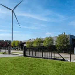 Poartă culisantă în consolă PI 95 – teren cu turbină eoliană în fundal