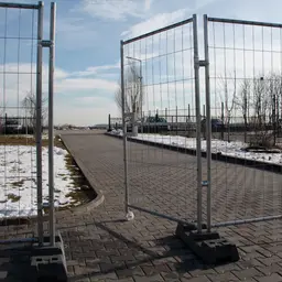 Poartă pietonală mobilă cu roată și încuietoare – deschisă spre un drum pavat