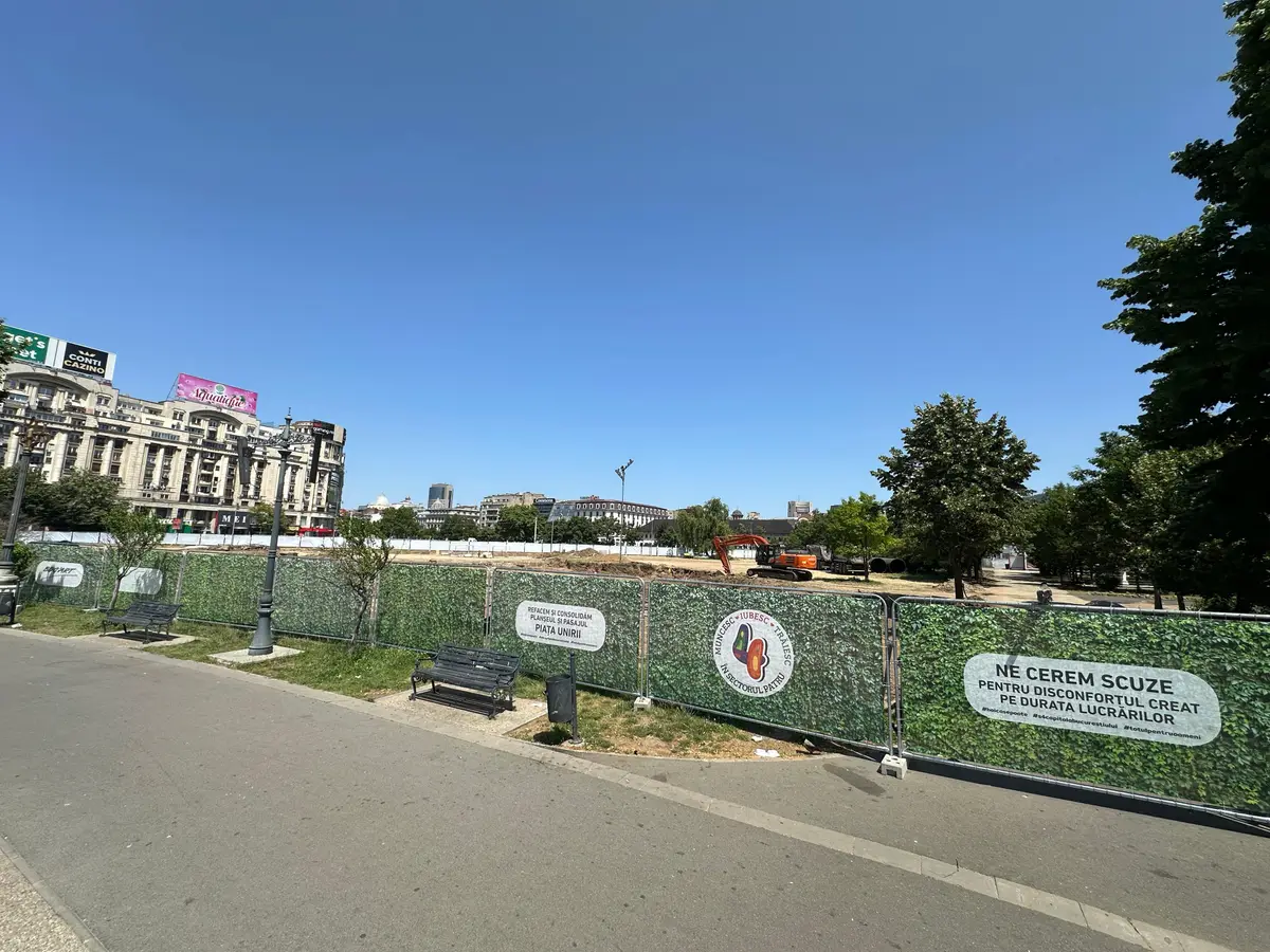 Împrejmuire de șantier cu panouri mobile RT, Bog'Art, Piața Unirii – pânză textilă, utilaje în fundal