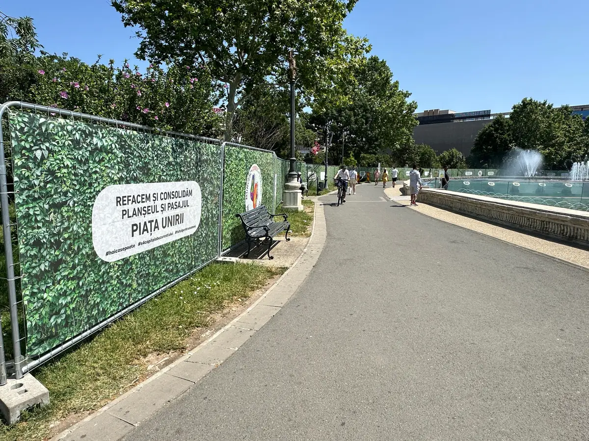 Împrejmuire de șantier cu panouri mobile RT, Bog'Art, Piața Unirii – parc cu fântână în fundal
