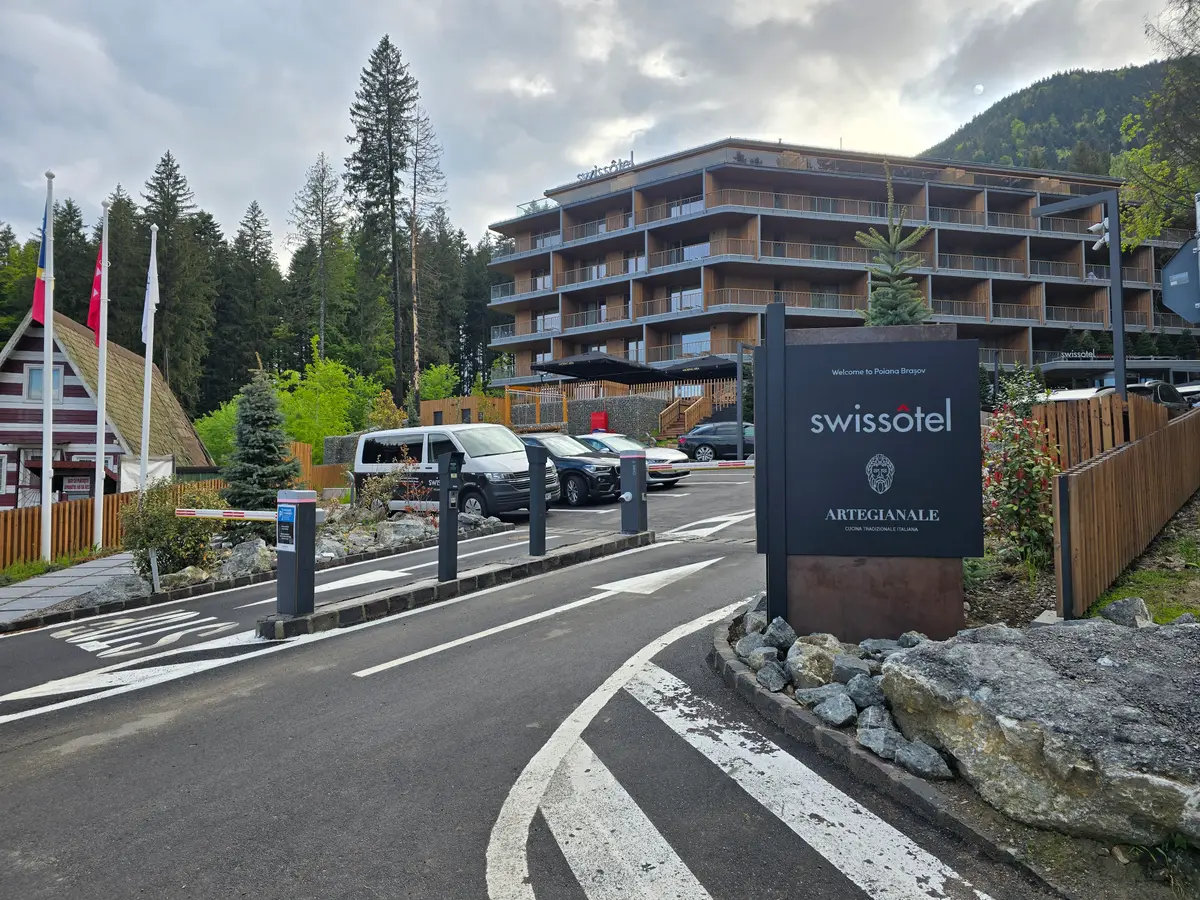 Gard din gabioane la hotelul Swissotel, Poiana Brașov – hotelul și parcarea, fundal montan