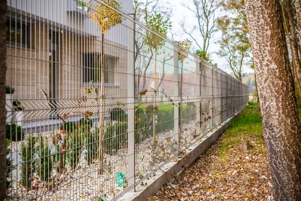 Gard panou bordurat Vega B 3D zincat 1.03 m, sârmă 5 mm – pe fundație de beton, lângă arbori