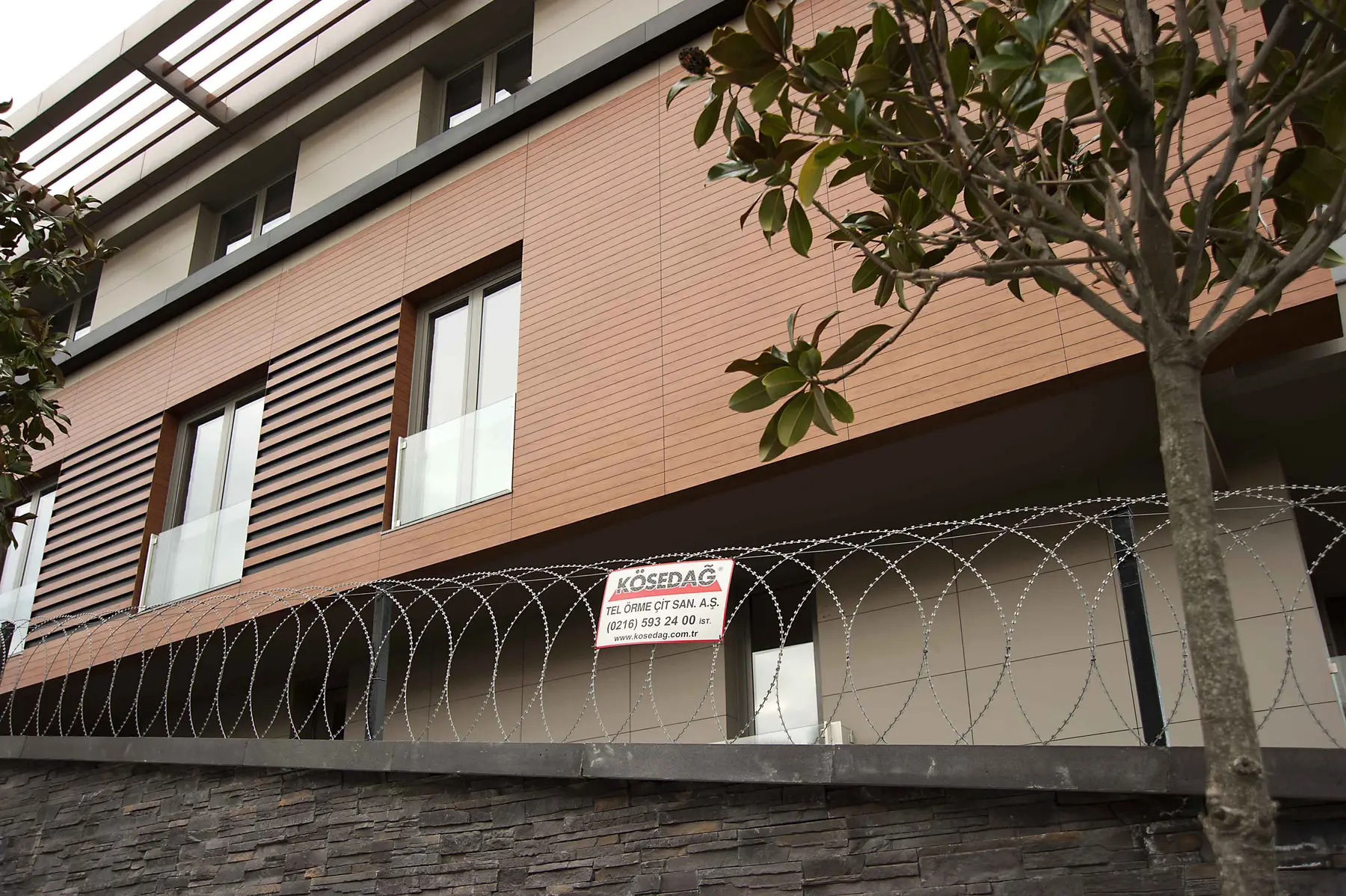 Accesoriu de gard: sârmă lamată concertina plană D 450 mm, întinsă 6 m – protecție în jurul unei clădiri moderne