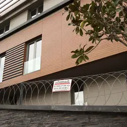 Accesoriu de gard: sârmă lamată concertina plană D 450 mm, întinsă 6 m – protecție în jurul unei clădiri moderne